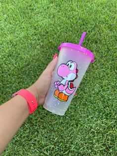 a hand holding a plastic cup with a cartoon character on it