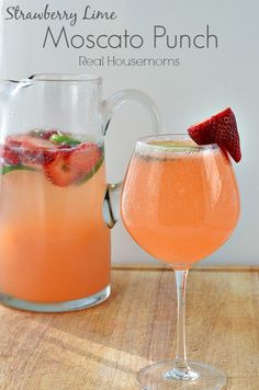 strawberry and lime moscata punch in a pitcher next to a glass with strawberries on the rim