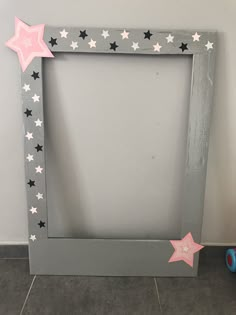 a gray frame with pink and white stars on the side, next to a blue toy