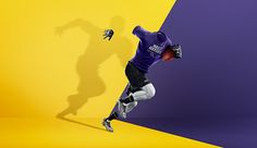 a soccer player in purple and yellow is kicking the ball with his arms out to catch it