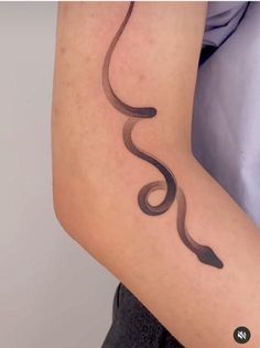 a woman's arm with a tattoo on it that is shaped like a snake