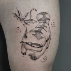 a black and white photo of a tattoo on the thigh