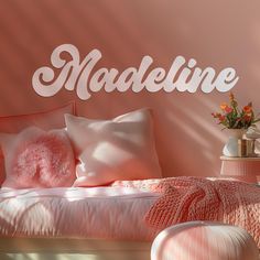 a bedroom with pink walls and white lettering on the wall that says madeline