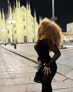 a woman in black dress standing on the street