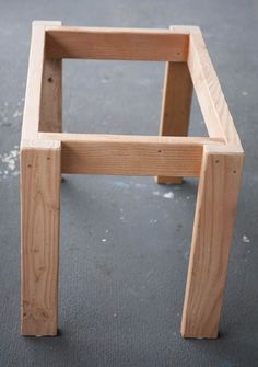 a wooden chair sitting on top of a cement floor