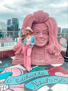 a woman standing in front of a pink statue