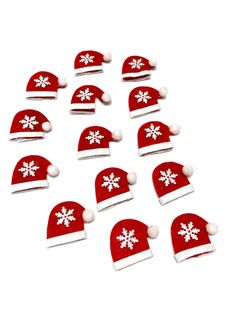 twelve red and white christmas hats with snowflakes on them are arranged in a pattern