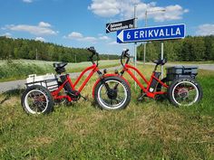 two bikes parked next to each other in the grass near a street sign that says gervalla