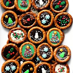 a box filled with lots of decorated cookies on top of a white table cloth covered in frosting