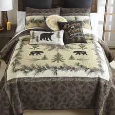 a bed covered in brown and white comforter next to a night stand with two lamps