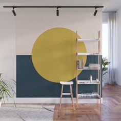 an orange and yellow circle on a white wall in a room with wooden floors, a ladder