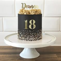 a black and white cake with gold sprinkles on top that says dream