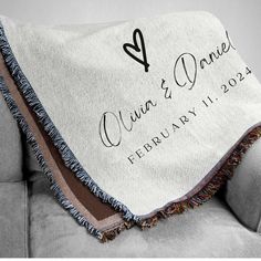 a personalized throw blanket on a couch with the date and wedding date printed on it