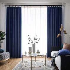 a living room with blue curtains and white furniture