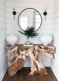 a table made out of driftwood with a mirror above it