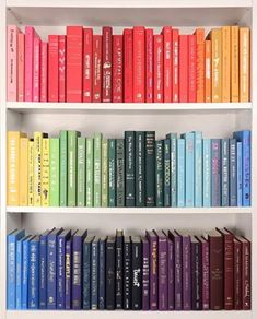 a book shelf filled with lots of books on top of white shelves next to each other