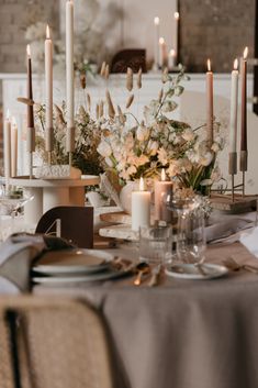 the table is set with candles, plates and napkins for an elegant wedding reception