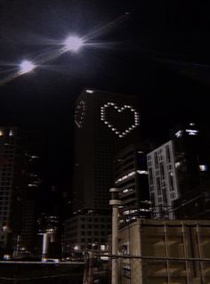 the city skyline is lit up at night with buildings and lights in the dark sky