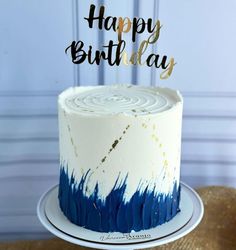 a white and blue cake sitting on top of a table