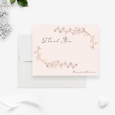 a thank card with the words, thank you in pink and gold on it next to some flowers