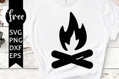 a white t - shirt with a black fire and crossed bones on it, sitting next to a plant