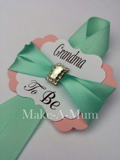 a green and pink ribbon with a bow on it that says grandma to be in the center