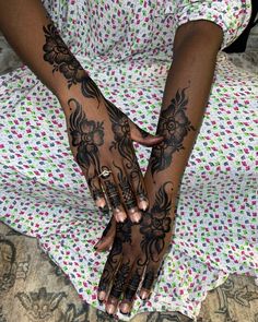 a woman's hands with henna tattoos on them