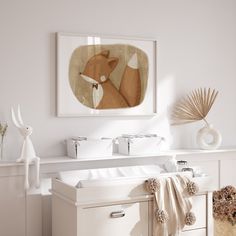 a bathroom with a sink, mirror and art on the wall above it's cabinets