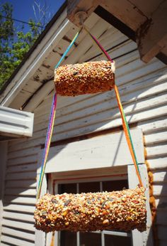 a bird feeder hanging from the side of a house with birdseed in it's mouth