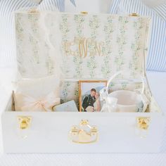 an open white suitcase filled with personal items and a couple's wedding photo in it