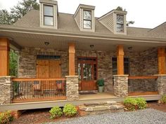 a stone house with wooden front doors and porches