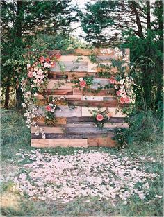 an old pallet is decorated with flowers and greenery