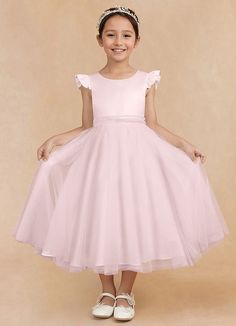 Hemi is an enchanting flower girl matte satin A-line dress that features a scoop neckline that is framed with adorable puff cap sleeves. A sash that comes to a removable bow in the back adds a charming accent. The tulle A-line silhouette allows your little one to feel delightfully free to twirl at every occasion. Princess Style Short Sleeve Dress For Confirmation, Elegant Summer Princess Dress For Confirmation, Princess Dress With Short Sleeves For Confirmation, Pink Fitted Dress For Confirmation, Fitted Dress With Bow For Confirmation, Fitted Pink Princess Dress For Confirmation, Pink Fitted Princess Dress For Confirmation, Princess Style Fitted Bridesmaid Dress For First Communion, First Communion Spring Dresses With Flutter Sleeve