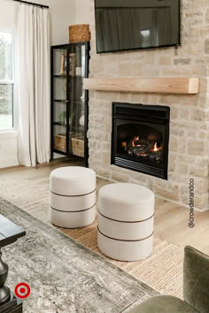 a living room with a fire place and two stools in front of the fireplace