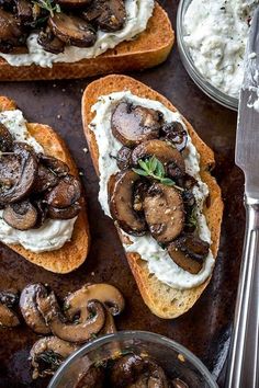 two slices of bread with mushrooms and cream cheese on top, next to silverware