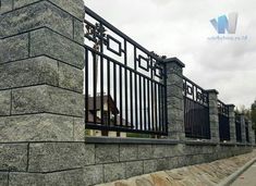 a stone wall with metal railings on it