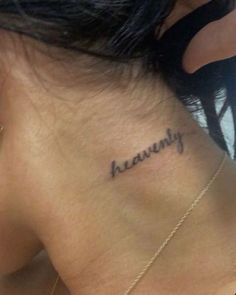 the back of a woman's neck with her name tattooed in cursive writing