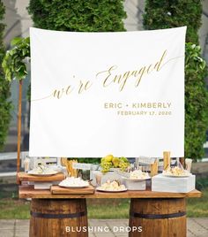 a sign that says we're engaged on top of a table with desserts