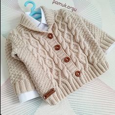 a knitted sweater with buttons on the collar and sleeves is displayed in front of a cardigan