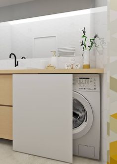 a washer sitting inside of a kitchen next to a counter top with a sink