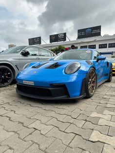 two blue sports cars parked next to each other