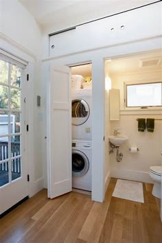 a washer and dryer in a small room next to a door that leads into a bathroom