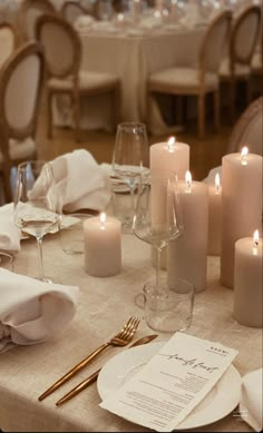 the table is set with white linens and candles for an elegant wedding reception or special event