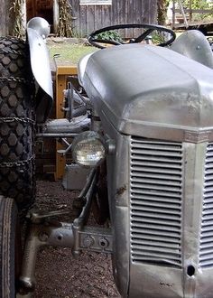 an old tractor is parked in the dirt