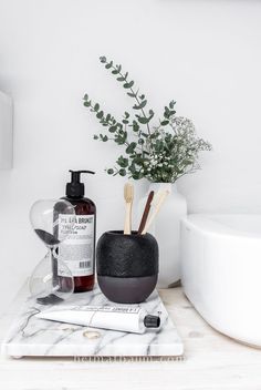 a bathroom counter with a soap dispenser, toothbrush holder and lotion