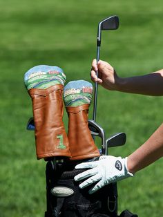 a pair of golf gloves on the back of a bag with a putter's club in it