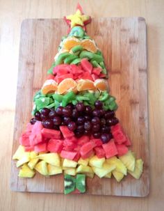 a christmas tree made out of fruit on a cutting board