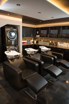 a washer and dryer in a room with lots of black leather chairs next to each other