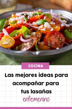 a metal bowl filled with lots of different types of vegetables on top of a green table cloth