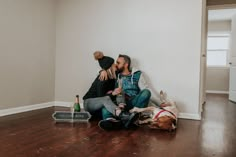 two people are sitting on the floor with their dogs